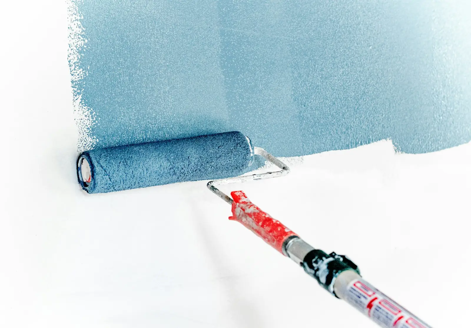 Roller spreading blue paint